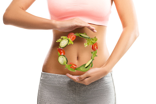 Fit, Young woman holding a circle made out of vegetables over her abdomen Image Source: Pixabay.com Safercures.com